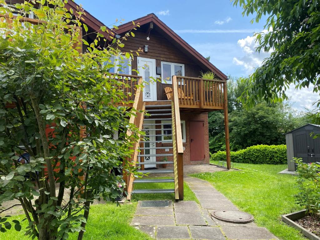 a house with a deck and a staircase in the yard at Ferienwohnung Michel in Glücksburg