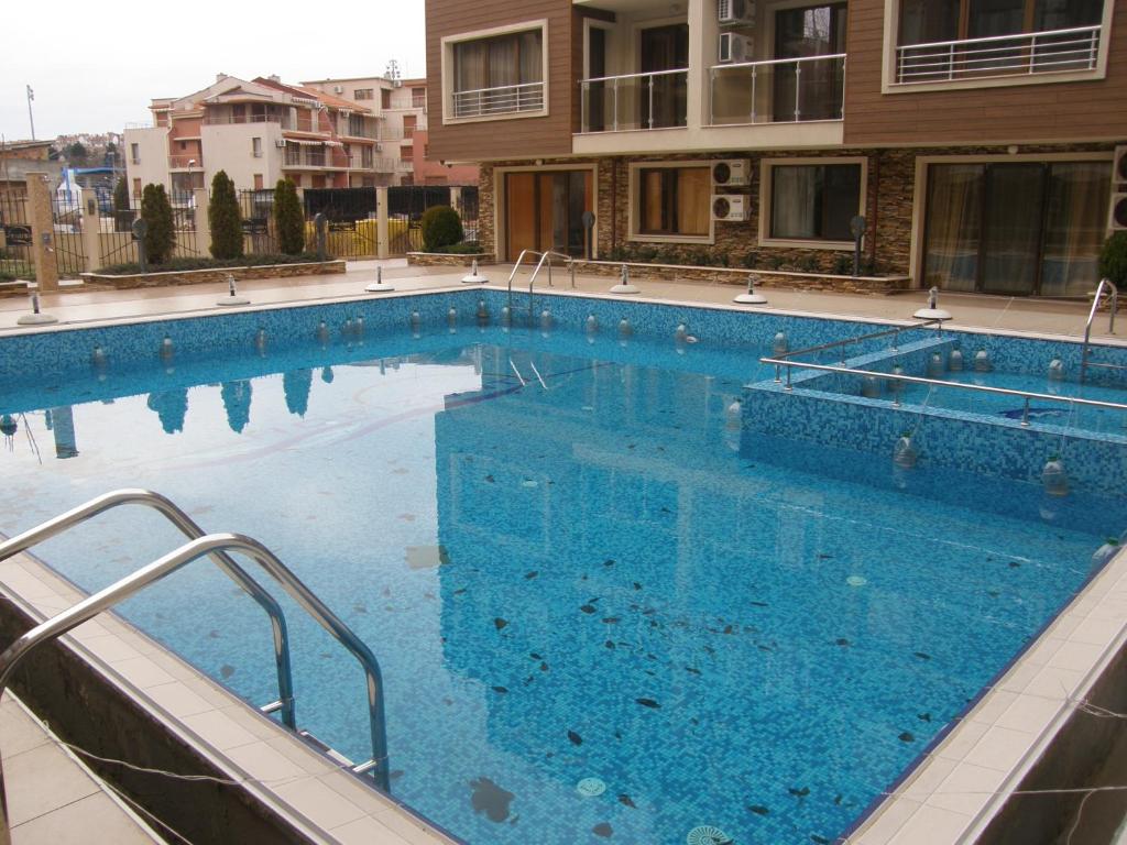 a large swimming pool with blue water in a building at Apartment Horisont 1 in Sozopol