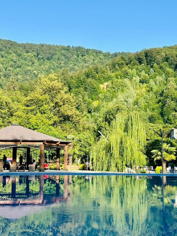 a swimming pool with a gazebo next to a mountain at Royal Palace Hotel, Lagodekhi in Lagodekhi