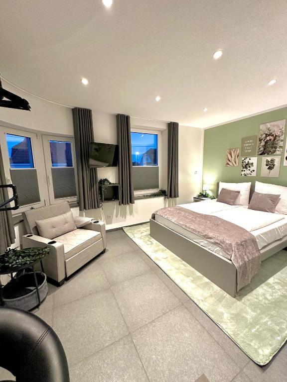 a bedroom with a bed and a couch and a chair at LH Apartments Aulendorf in Aulendorf