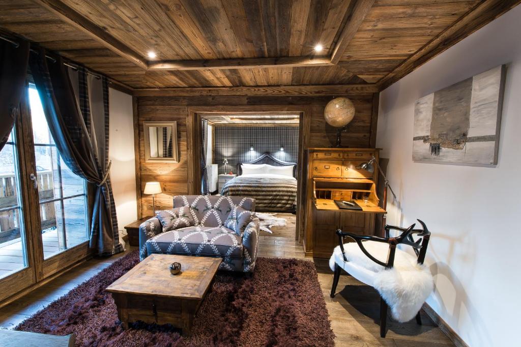 a living room with a couch and a bed at Le Chalet Blanc in Megève