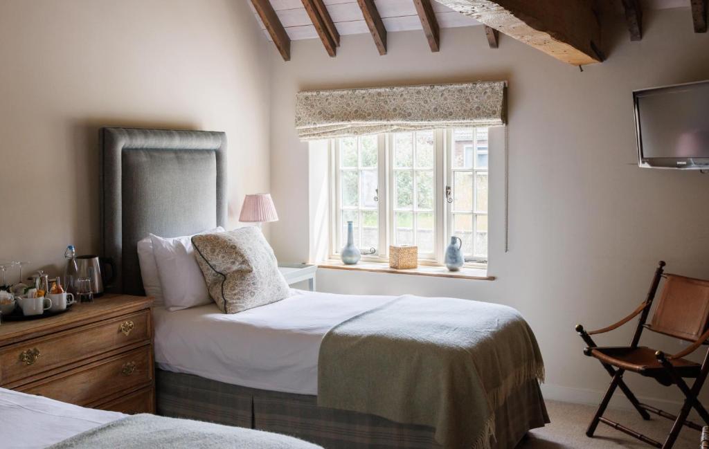 a bedroom with two beds and a window at The Three Daggers in Edington