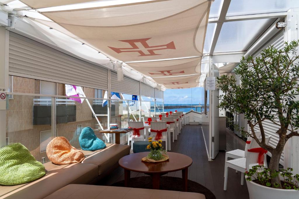 a room with couches and tables and windows at House Barra Beach in Praia da Barra