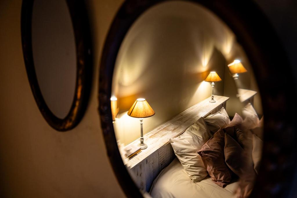 eine Spiegelung eines Bettes mit zwei Lampen darauf in der Unterkunft B&B Sapere in Genoelselderen