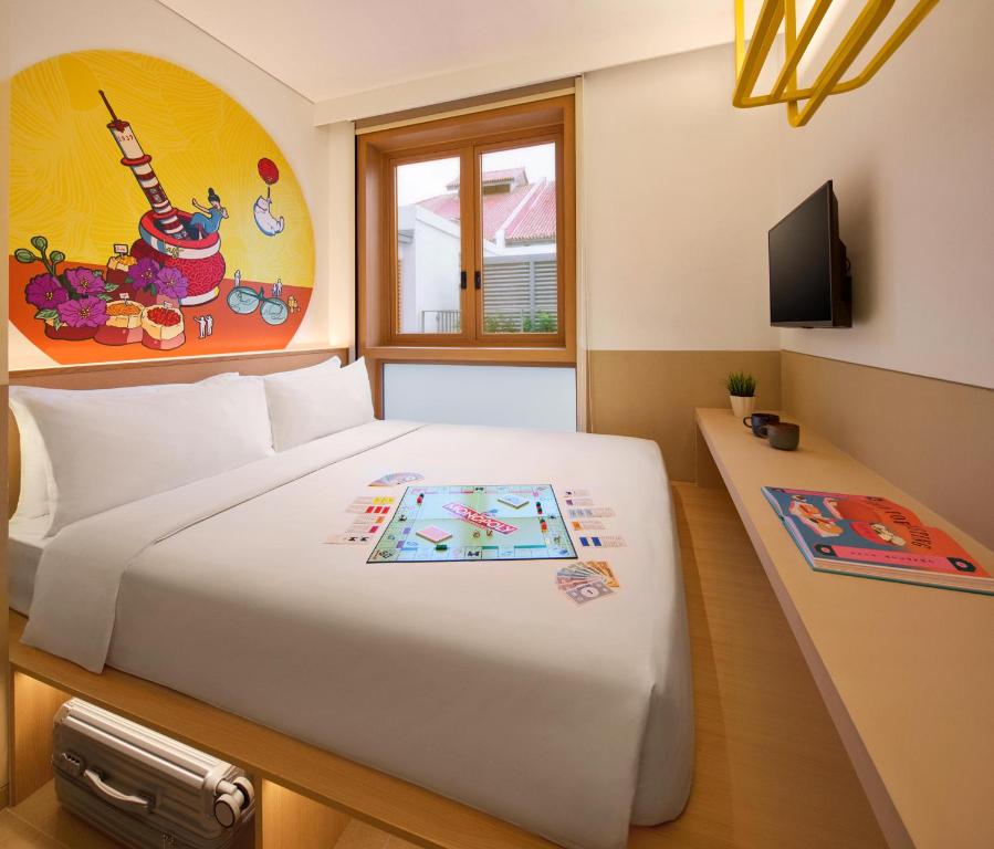 a bedroom with a large white bed and a tv at lyf Chinatown Singapore in Singapore