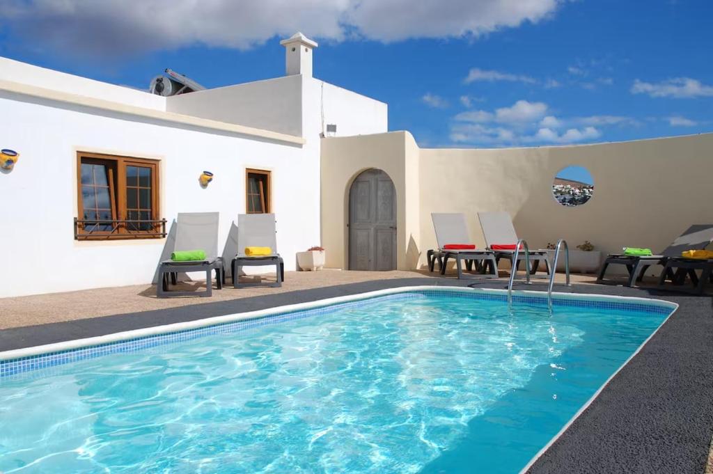 a villa with a swimming pool in front of a house at Villa Ann Lanzarote in Nazaret