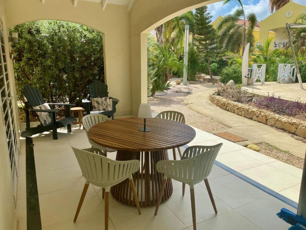 a wooden table and chairs on a patio at Caracara D1 Relax & Dive Resort Bonaire Village in Kralendijk