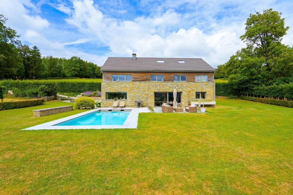 a stone house with a pool in the yard at Villa Winbomont in Malmedy