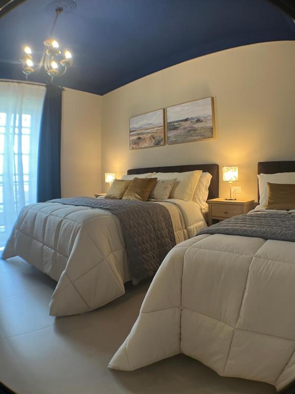 a bedroom with two beds and a window at Harmony Suite in Aprilia