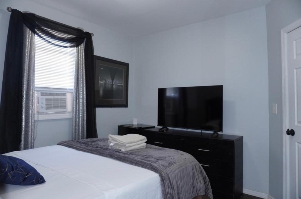 a bedroom with a bed and a flat screen tv at West New York room 15 in West New York