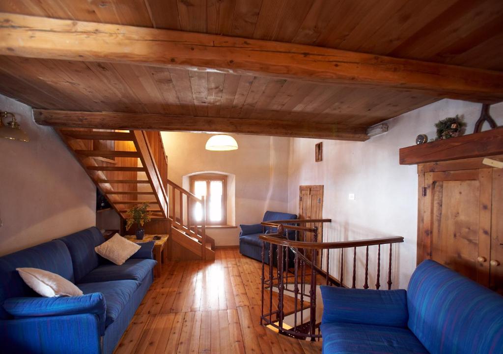 a living room with blue couches and a staircase at Maison Carré in Rhêmes-Notre-Dame