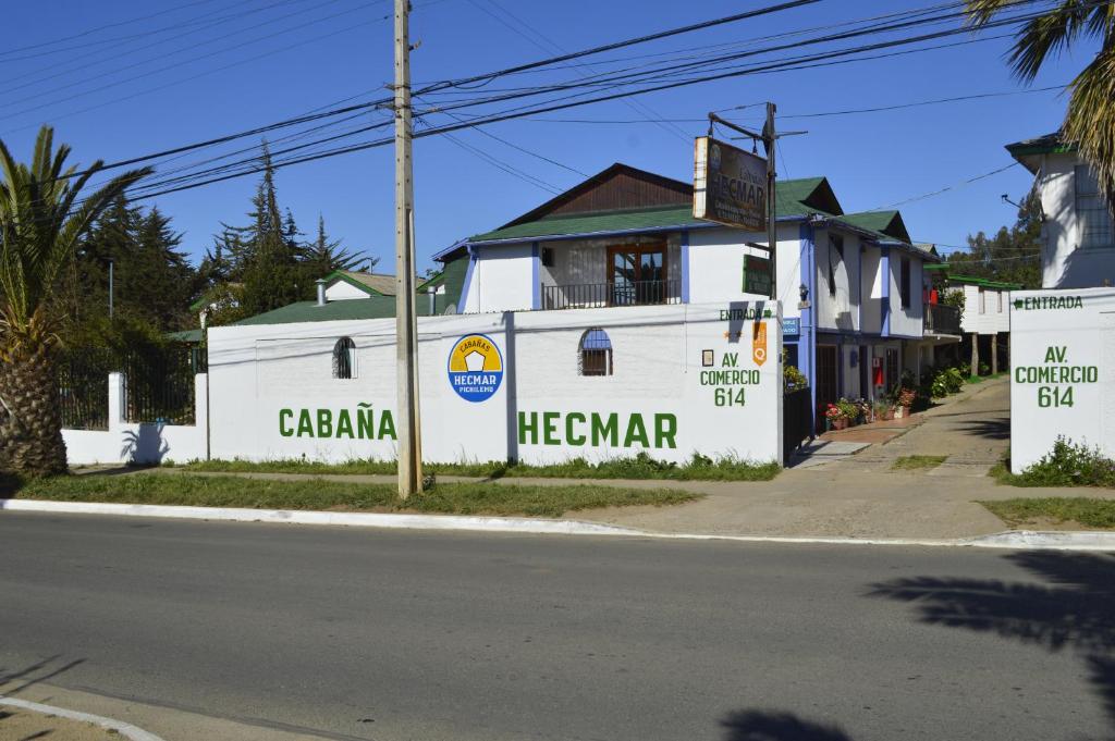 un edificio blanco al lado de una calle en Cabañas Hecmar, en Pichilemu
