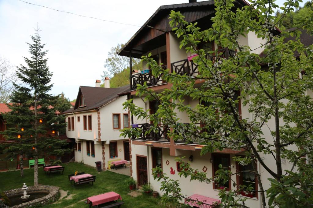 a large white building with a balcony at ABANT DORT MEVSİM KONAĞI HOSTEL in Dereceören