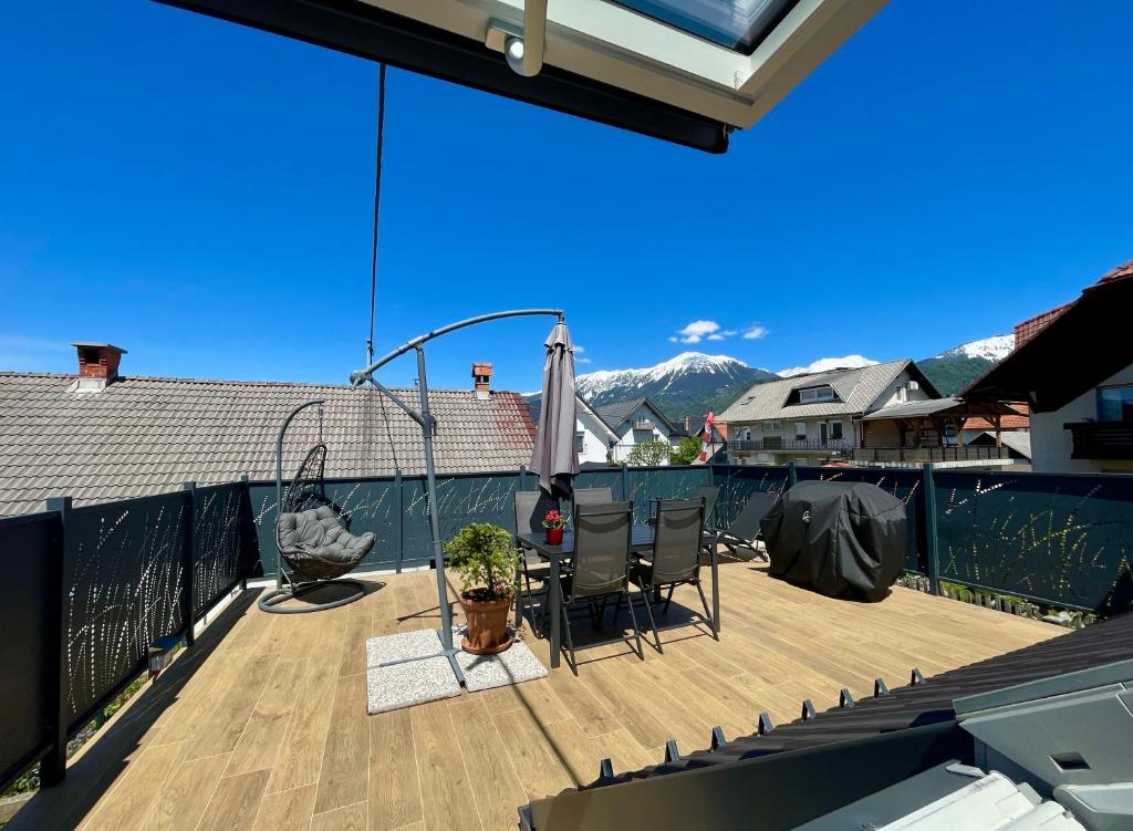 a deck with a table and chairs on a balcony at AERO Apartmaji Lesce-Bled in Lesce