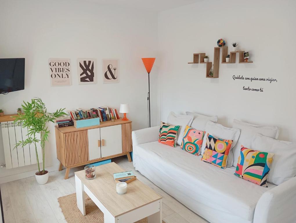 a living room with a white couch and a table at La Casita de Suances 1- Jardín y Parking, Ideal Familias y Mascotas in Suances