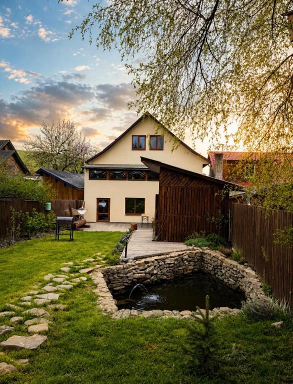 a house with a pond in the yard at Pstrug House in Yasinya