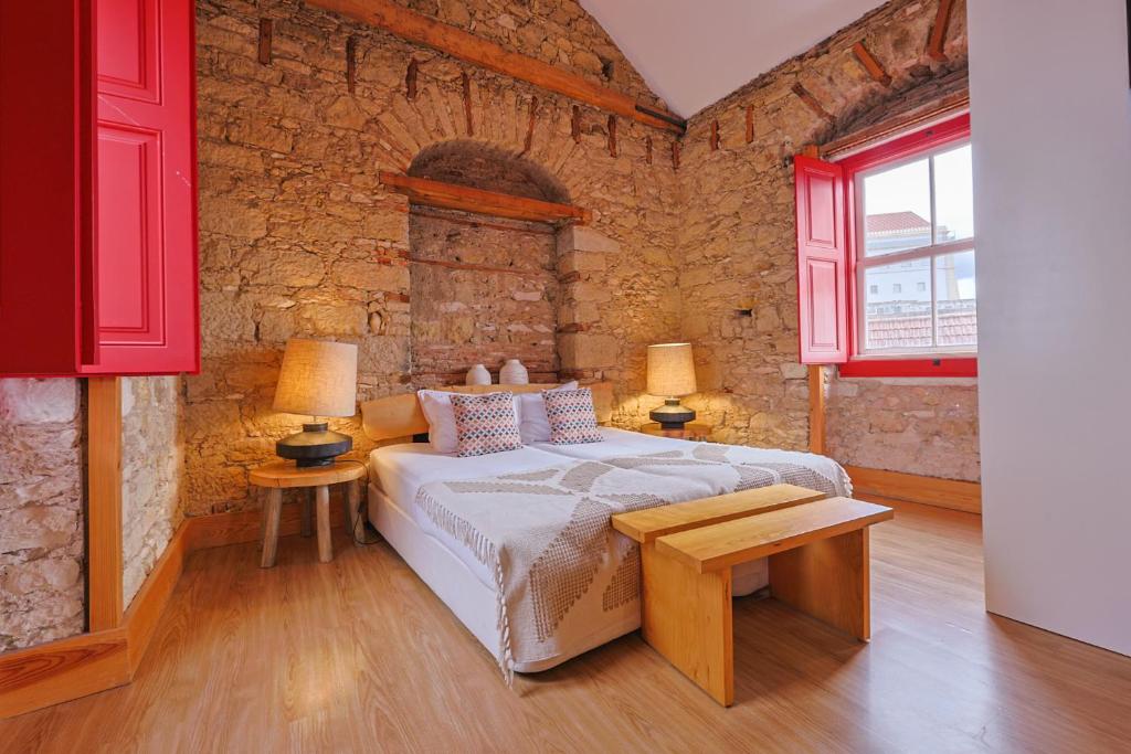 a bedroom with a bed and two tables and two lamps at Casa da Sé by PURUS in Coimbra