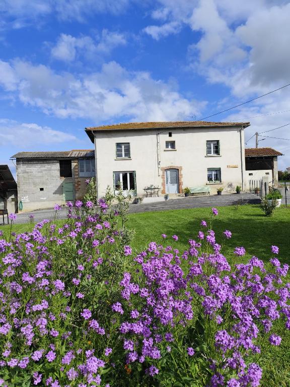 a house with purple flowers in front of it at Gîte menthe à l'eau in Ciadoux