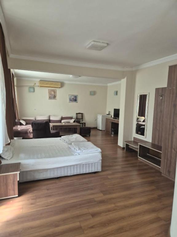 a large bedroom with a bed and a couch at Хотел М in Asenovgrad