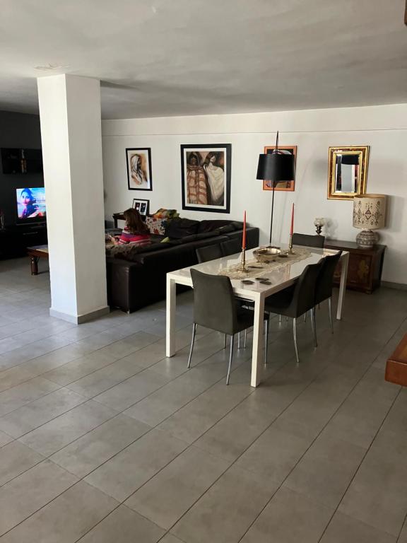 a living room with a table and chairs and a couch at Beau Rez de Jardin in Ariana