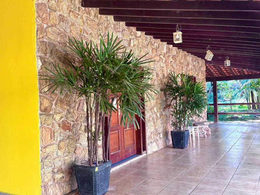 a building with two potted plants in front of a door at quarto suíte privativo em campinas para até 3 pessoas in Campinas
