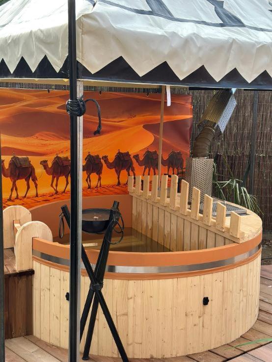 a hot tub in a circus with a painting of horses at Lodge SAHARA in Arques