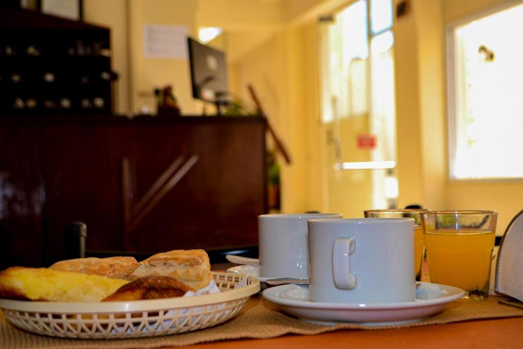 a table with two cups and some pastries on it at Hotel Ke Kuul in Salta