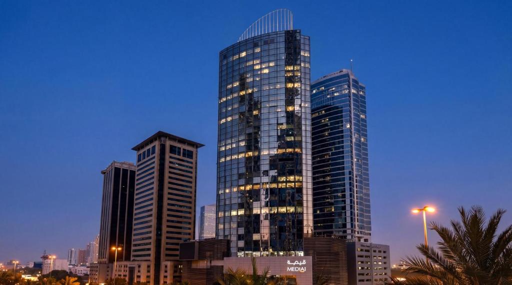 two tall skyscrapers in a city at night at Media One Hotel Dubai, WorldHotels Crafted in Dubai