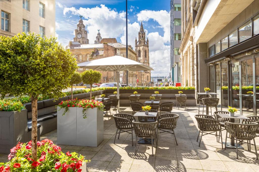 an outdoor patio with tables and chairs and a church at Hotel Indigo Liverpool by IHG in Liverpool
