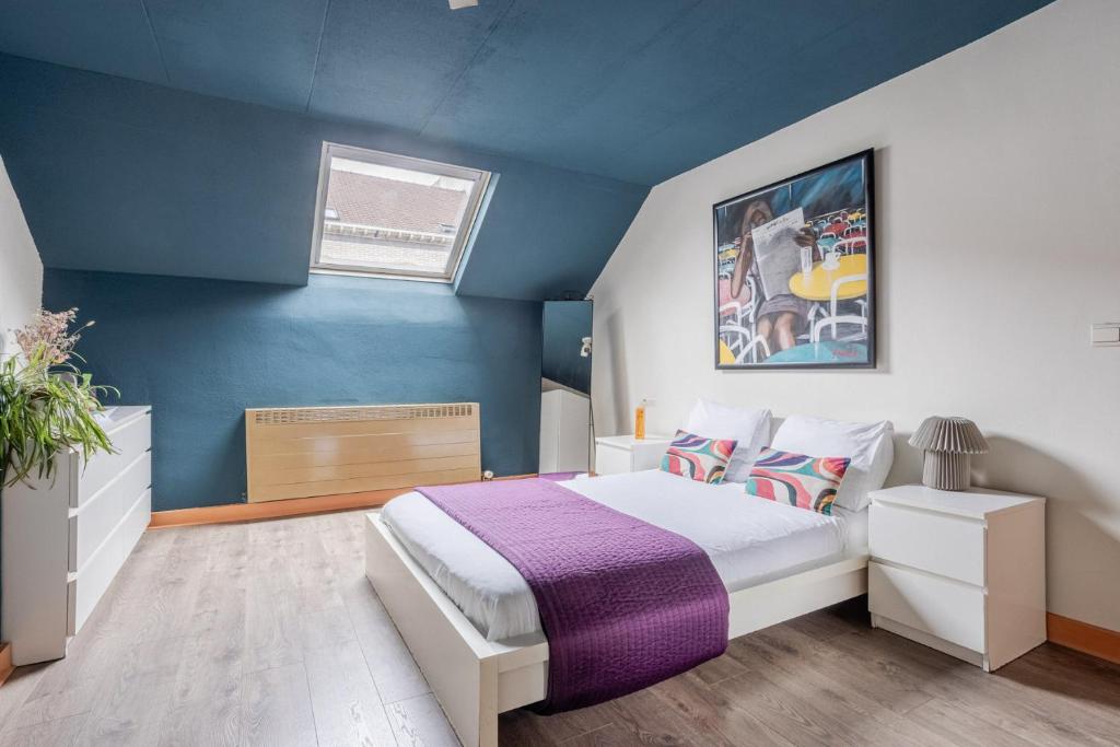 a bedroom with a bed and a blue wall at Brussels Guest House in Brussels
