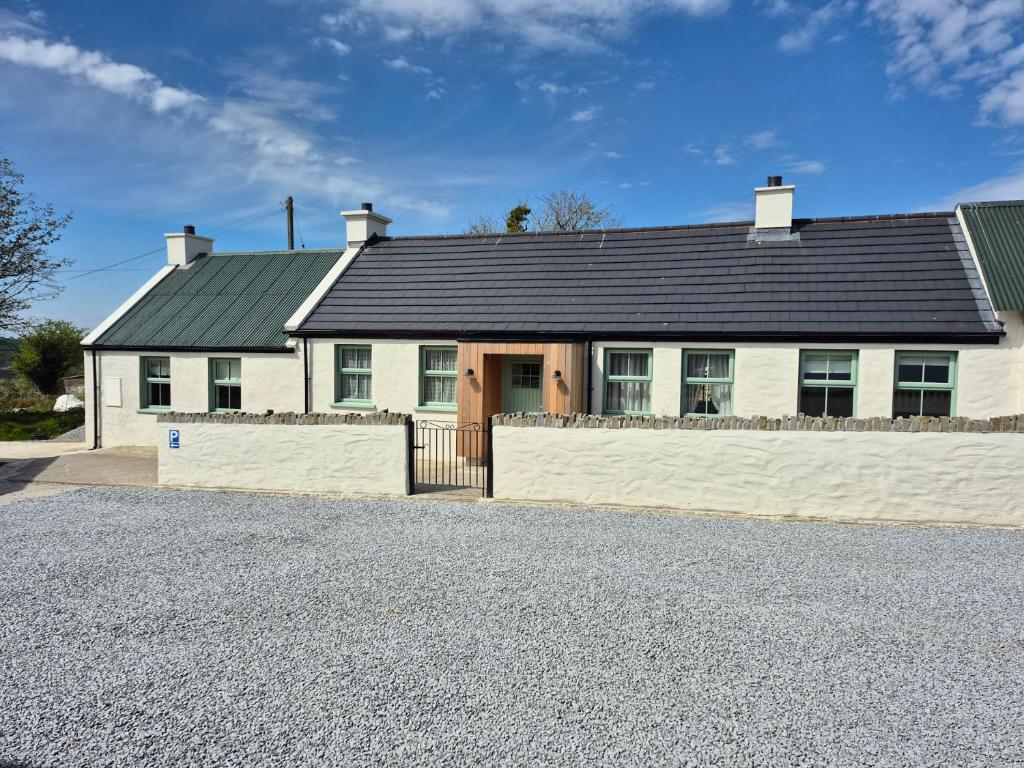 a white house with a black roof at Annies Farm Cottage in Derry Londonderry