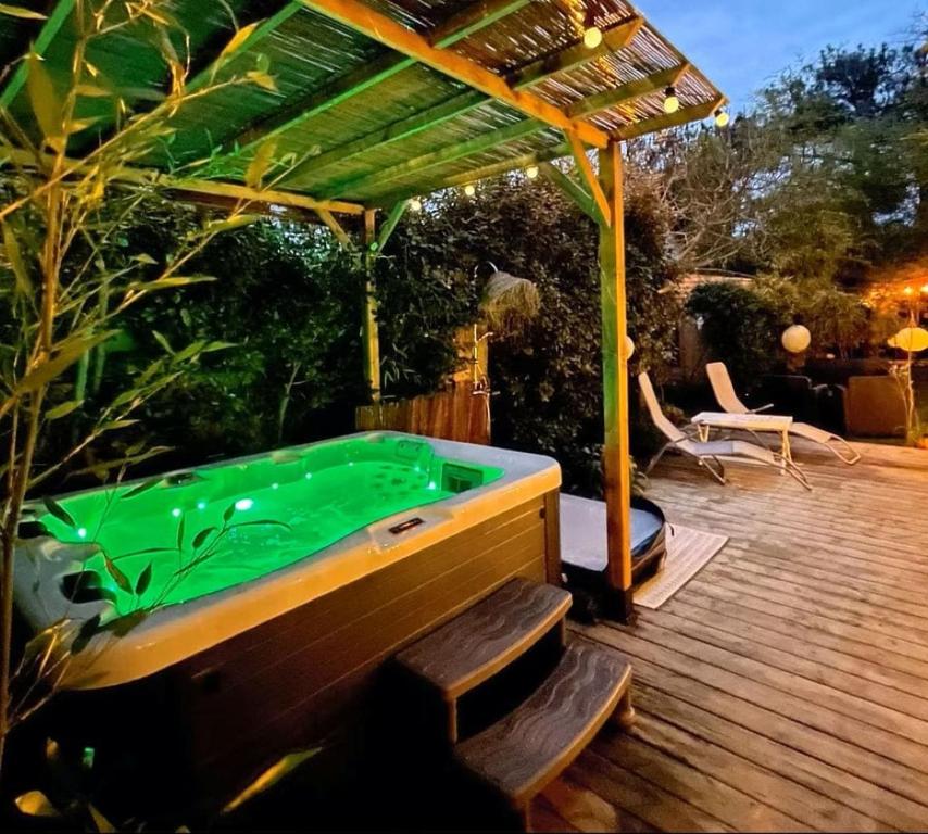 a pool table on a wooden deck with a pergola at Cabane du Bertic in Lège-Cap-Ferret