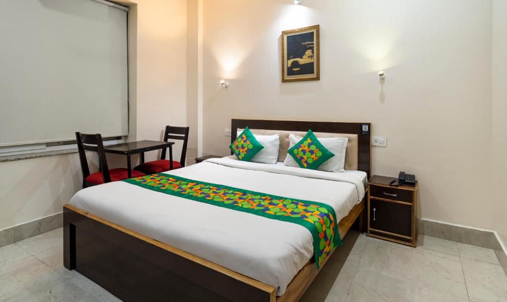 a bedroom with a bed and a table and a chair at Treebo AK Residency, Tapovan in Kainūr