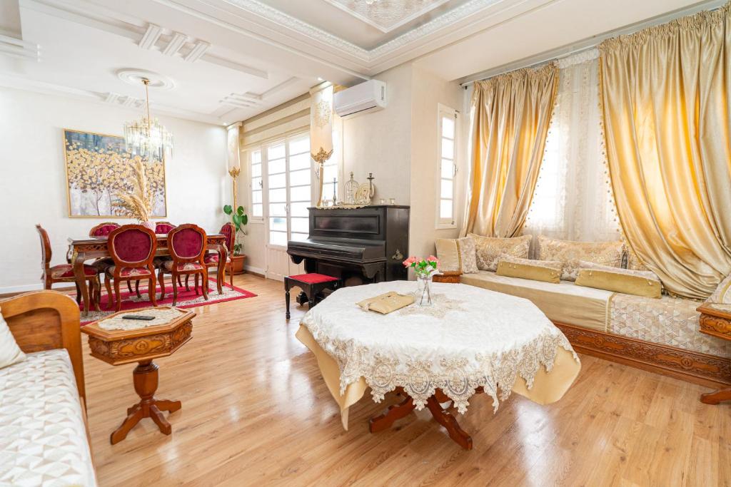 a living room with a table and a piano at Royal Moroccan Suite Central Tangier in Tangier