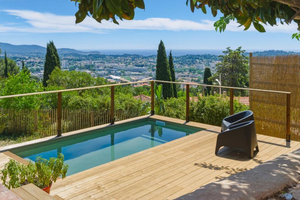 a swimming pool on a wooden deck with a view at Villa vue mer panoramique & piscine chauffée in Toulon