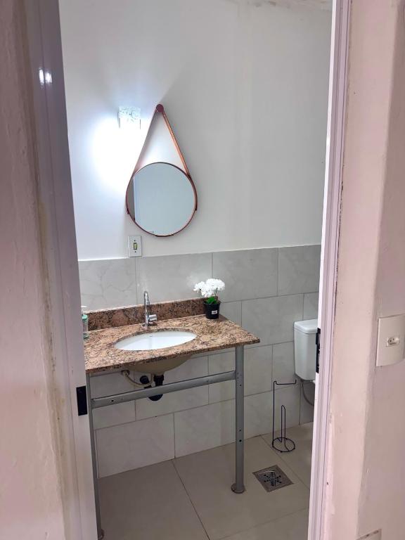 a bathroom with a sink and a mirror on the wall at quarto suíte privativo em campinas para até 4 pessoas in Campinas