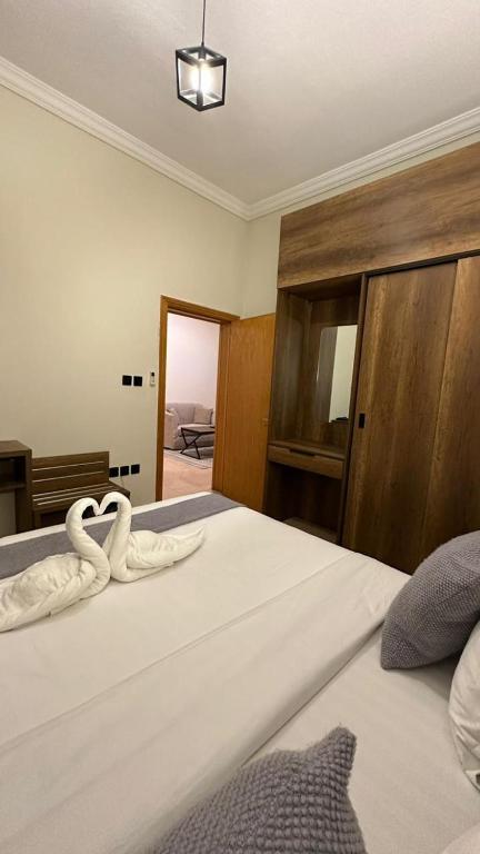 a bedroom with a bed with two swans on it at ركن النسيم للشقق الفندقية Rukn Al - Naseam Hotel Apartment in Jeddah