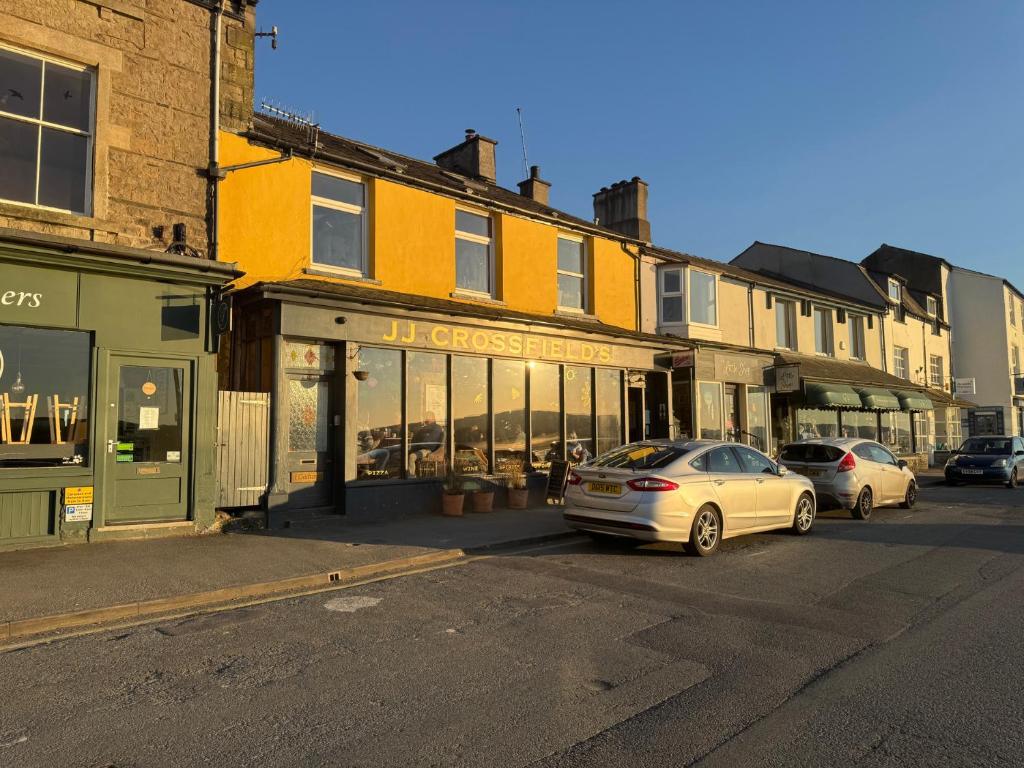 a city street with cars parked in front of buildings at Flat 2, Dorstan in Carnforth