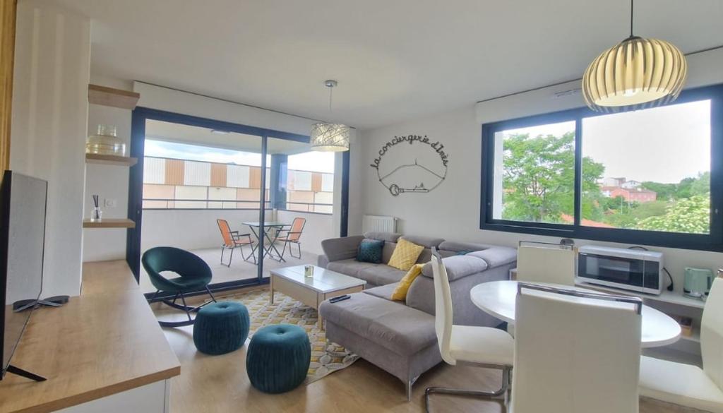 a living room with a couch and a table at Le Savannah #Parking#Terrasse in Clermont-Ferrand