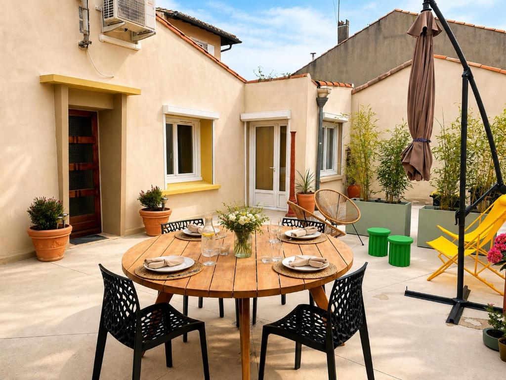 a patio with a wooden table and chairs at Maison entière cosy calme parking animaux ok in Carcassonne