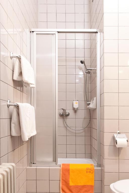 a bathroom with a shower and a yellow towel at Hotel Merkur - Jablonec nad Nisou in Jablonec nad Nisou