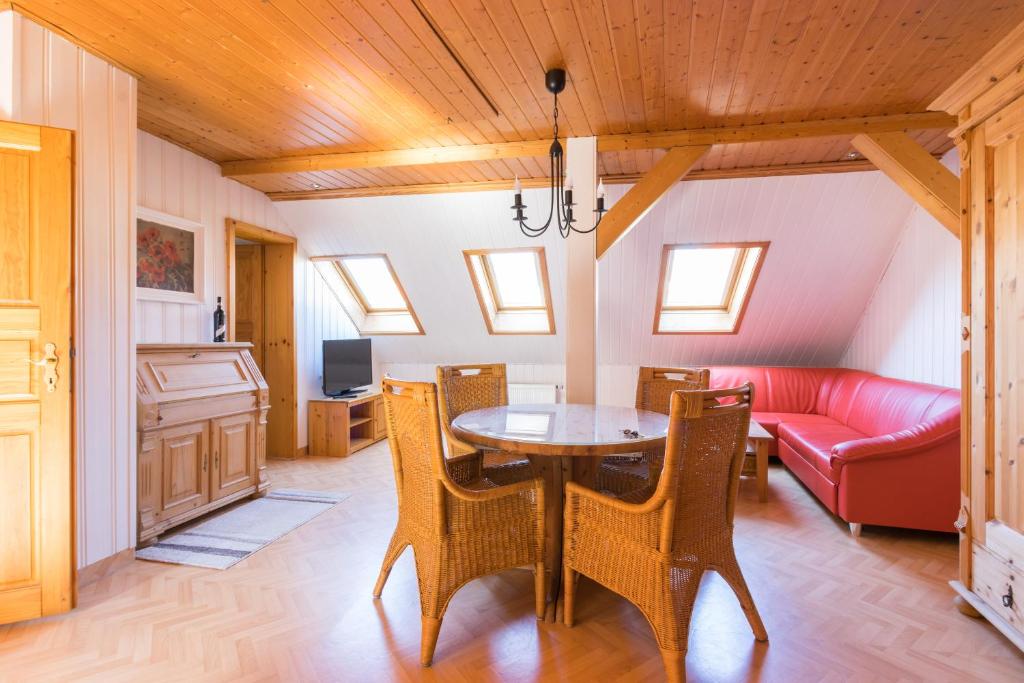 a dining room with a table and a red couch at Apartments Ilmtal-Jena in Jena