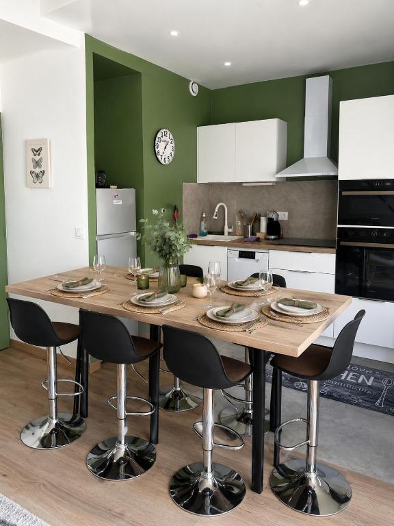 a kitchen with a wooden table and chairs in a kitchen at Duplex cosy 4-6 pers - Terrasse - Grenoble - Vercors in Claix
