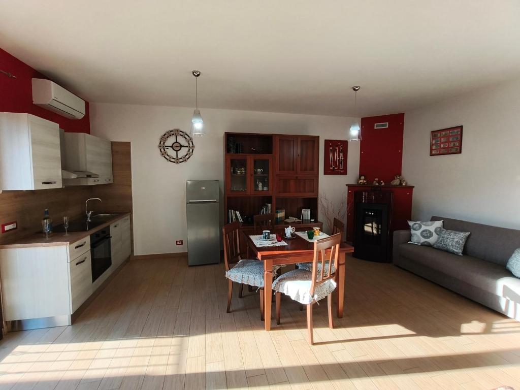a kitchen and living room with a table and a couch at Monolocale moderno in centro storico in Scano Montiferro