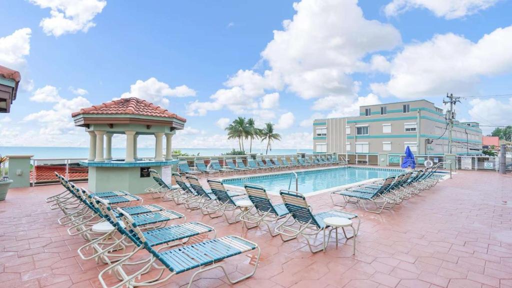a pool with chairs and a gazebo next to a building at Hollywood Beach Tower - Studio Suite in Hollywood