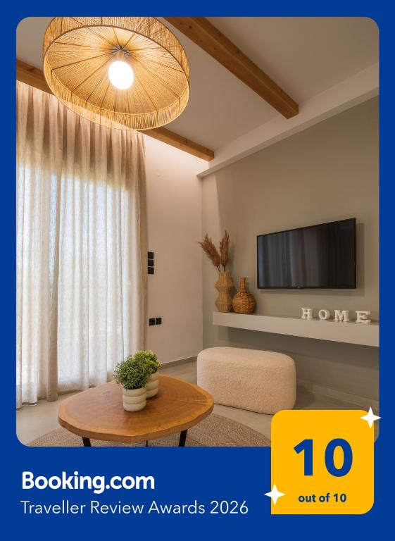 a living room with a table and a tv at Palaia Luxury Suite in Volos