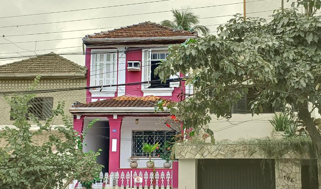 a pink house with a window and a fence at Muito espaço e natureza no meio da cidade in Santos