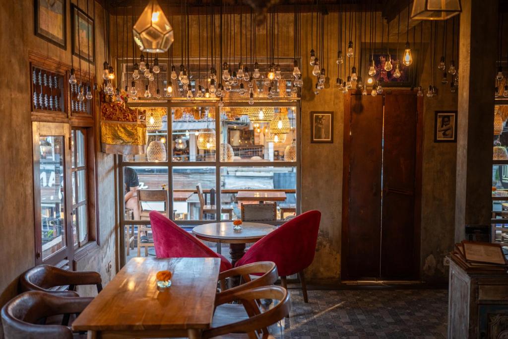 a restaurant with a table and chairs and a window at Aru House Ubud in Ubud