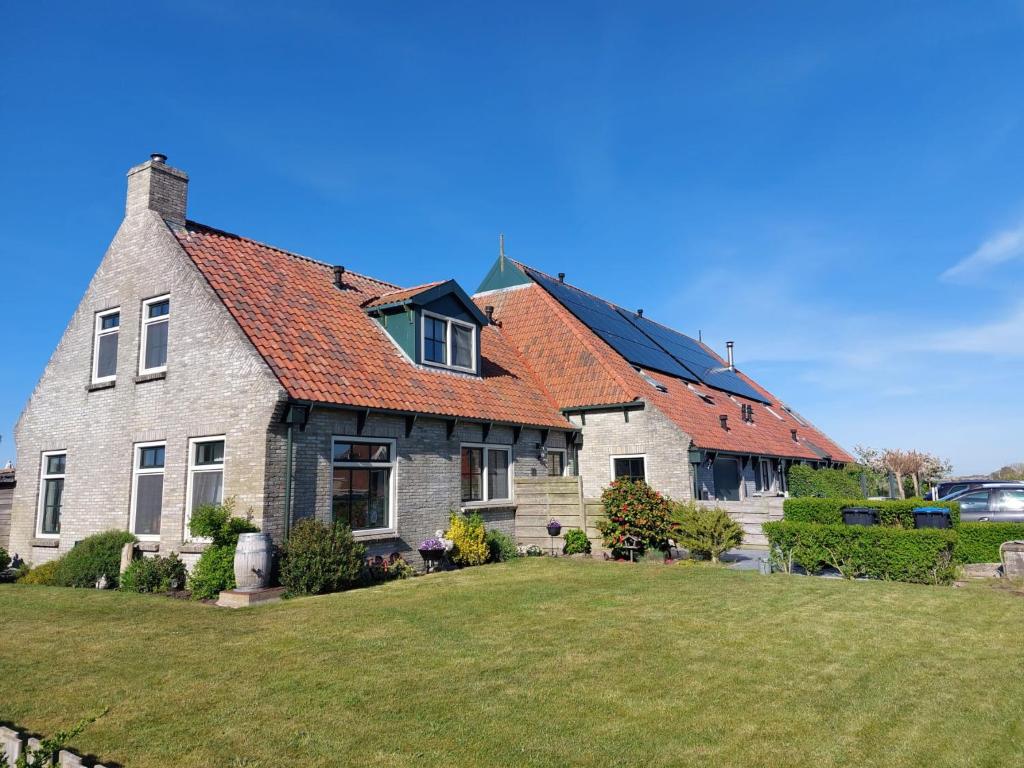 a large brick house with a red roof at Uut in Thuus in Buren