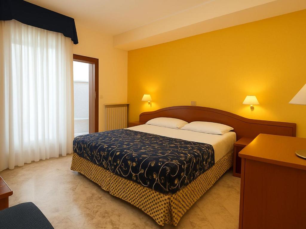 a hotel room with a bed and a window at Smart Rooms Miramare in Sottomarina